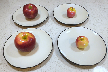 photo of 4 plates each with one apple. Two of the apples are regular size, and two are tiny.